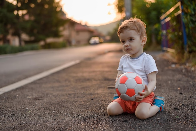 Maluch Bawi Się Piłką Futbolową Na świeżym Powietrzu