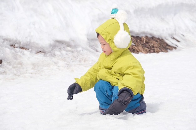 Maluch Chłopiec Dziecko Nosi Nauszniki, Rękawice śnieżne Bawiące Się W śniegu