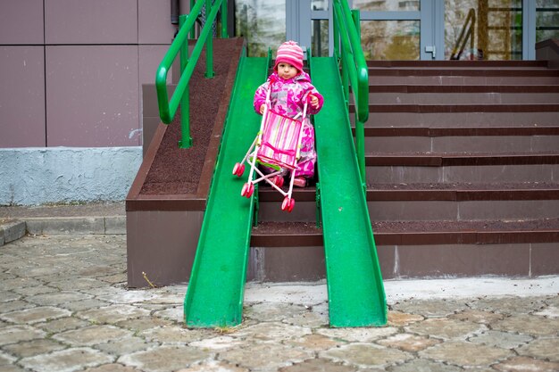 Zdjęcie maluch ciągnie zabawkowy wózek po rampie schodów