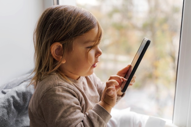 Maluch dziecko przy użyciu telefonu w domu