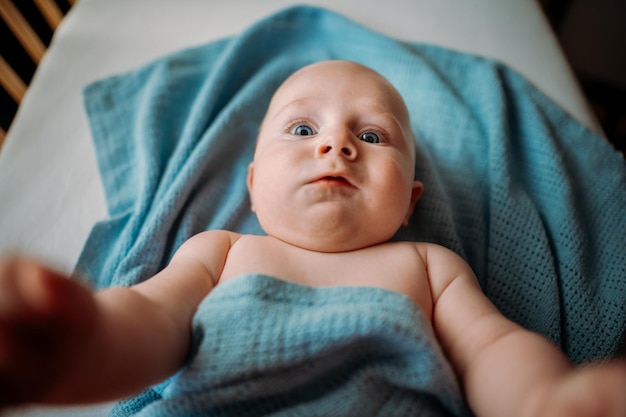 Zdjęcie maluch robi selfie w łóżeczku trzymając smartfon przestraszona twarz