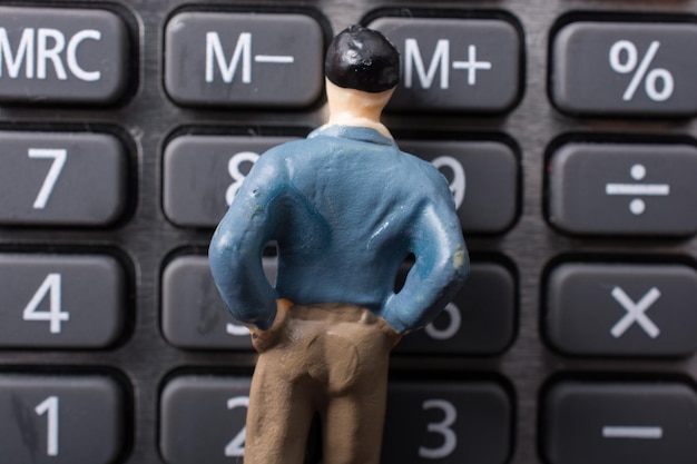 Zdjęcie malutka figurka mężczyzna model na kalkulatorze