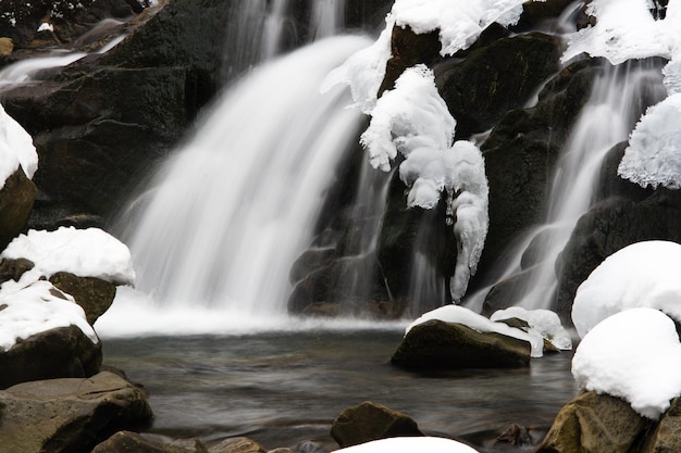 mały aktywny wodospad czysty górski strumień śnieżny zimowy krajobraz dzikie tło