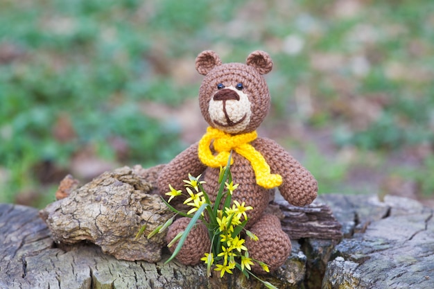 Mały, brązowy niedźwiedź z żółtym szalikiem. Dzianinowa zabawka, ręcznie robiona, amigurumi