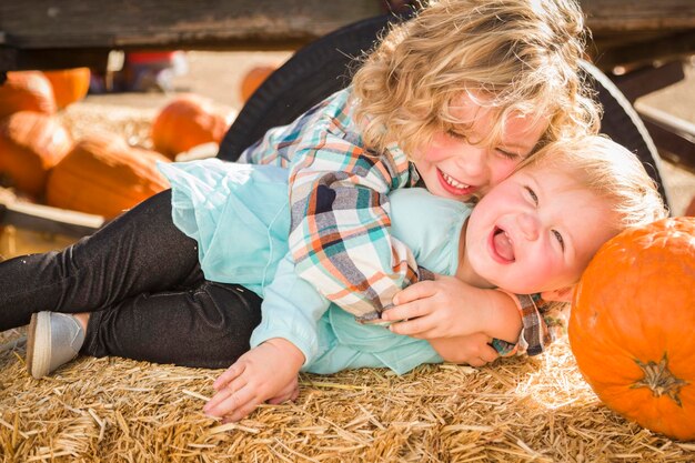 Mały chłopiec bawi się ze swoją małą siostrą w Pumpkin Patch