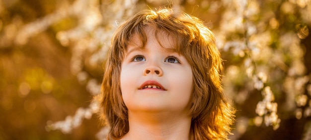 Zdjęcie mały chłopiec chodzi na świeżym powietrzu wiosna pogoda słońce świeci hild relaks pod słońcem dziecko chłopiec wiosna