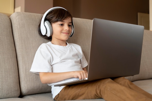 Mały chłopiec grający w grę wideo na swoim laptopie