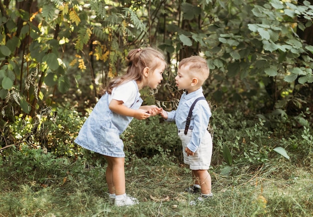 Mały chłopiec i dziewczynka spacerują po parku Portret szczęśliwych dzieci w jasny słoneczny dzień Przyjaźń Letnie wakacje