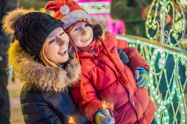 Mały chłopiec i jego matka z zimnymi ogniami Świąteczna iluminacja na Boże Narodzenie