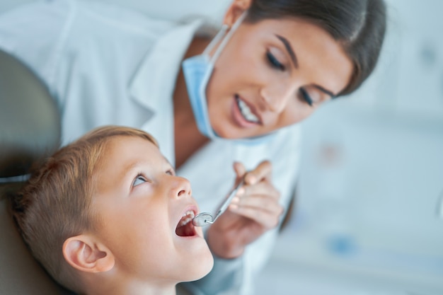 Mały chłopiec i kobieta dentysta w gabinecie stomatologicznym
