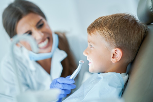 Mały chłopiec i kobieta dentysta w gabinecie stomatologicznym