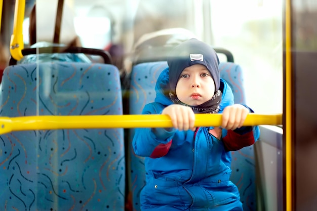 Mały chłopiec jeździ autobusem Poważny chłopiec patrzy w kamerę