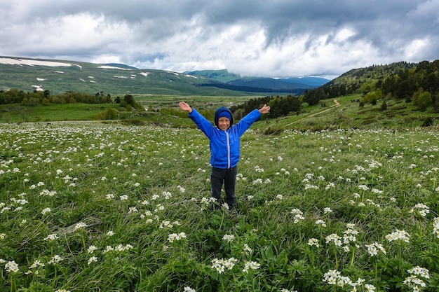Mały chłopiec na kwitnących alpejskich łąkach LagoNaki Adygea Rosja 2021