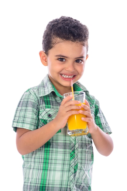 Mały chłopiec pije sok pomarańczowy