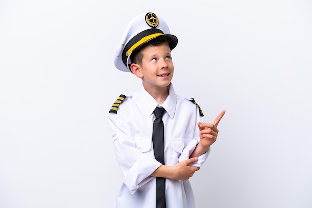 Mały chłopiec pilota samolotu na białym tle wskazujący świetny pomysł