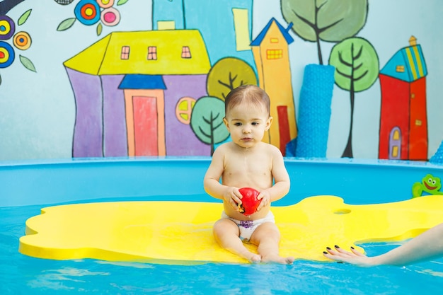 Zdjęcie mały chłopiec pływa w basenie uczy dzieci pływać szkoła pływania dla dzieci