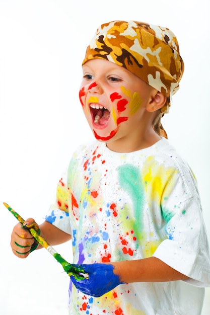 Mały chłopiec poplamiony farbą rysuje
