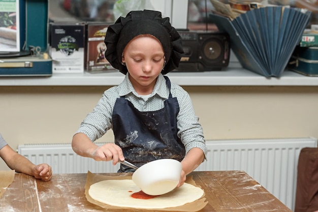 Mały chłopiec robi pizzę?