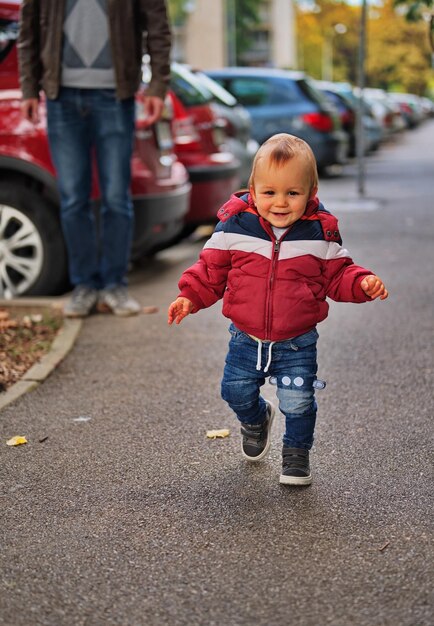 Zdjęcie mały chłopiec robi swoje pierwsze kroki ulicą.