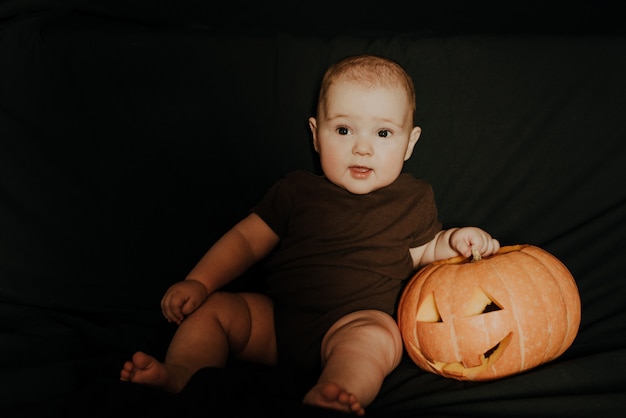 Mały chłopiec siedzi z dyni Halloween Jack