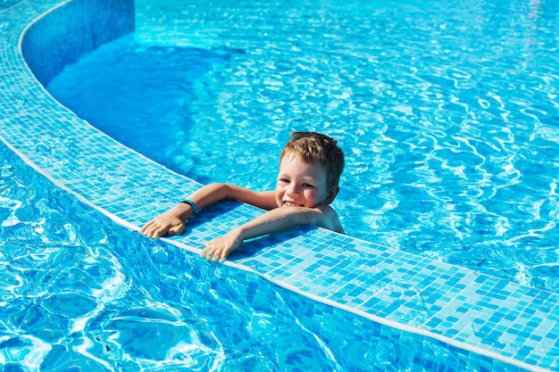 Mały chłopiec uczy się pływać. Koncepcja wakacji letnich.