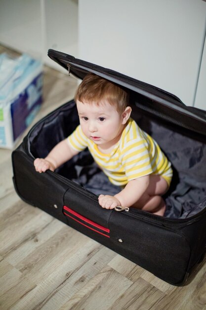 Mały chłopiec w czarnej walizce Czekając na wakacje