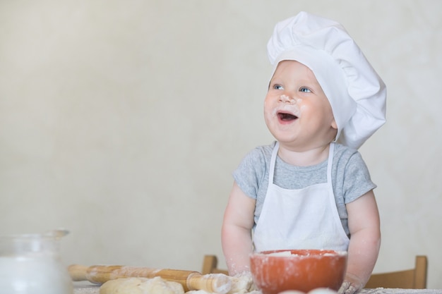 Mały Chłopiec W Garniturze Kucharza Rzeźbi Ciasto Małe Dziecko Scullion Robi Obiad W Garniturze Szefa Kuchni