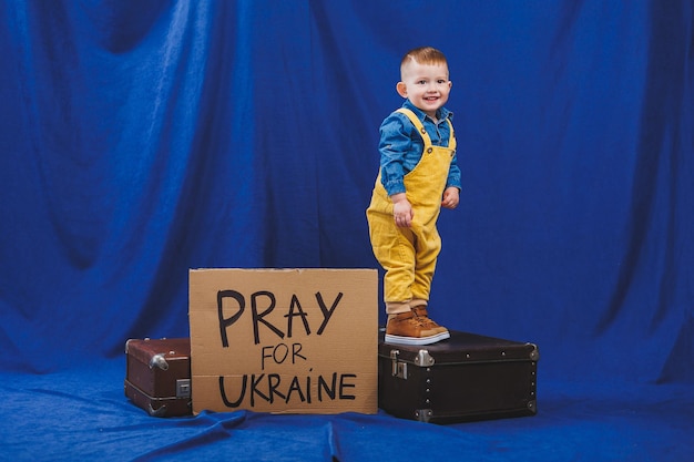 Mały chłopiec w skórzanej kurtce z napisem Modlę się za Ukrainę Drewniany samolot z materiału przyjaznego dla środowiska