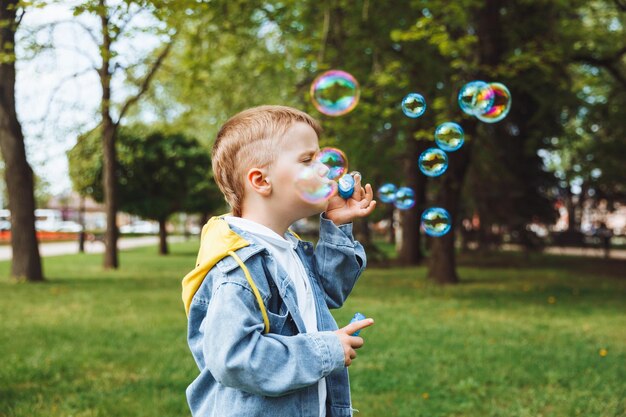 Mały chłopiec z bańkami mydlanymi w parku Wiosenny słoneczny dzień aktywne gry dla dzieci