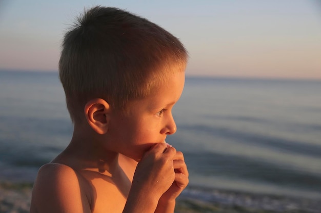 Mały chłopiec z cukierkami na morzu