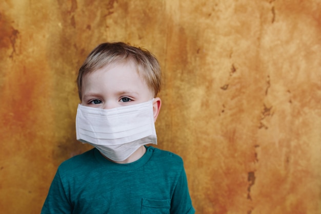 Mały chłopiec z medyczną ochronną maską na twarzy