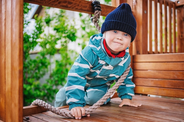 Zdjęcie mały chłopiec z zespołem downa bawi się na placu zabaw, selektywne skupienie