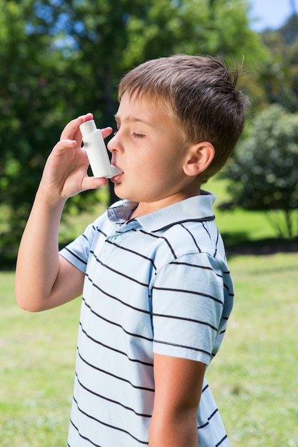 Mały chłopiec za pomocą swojego inhalatora