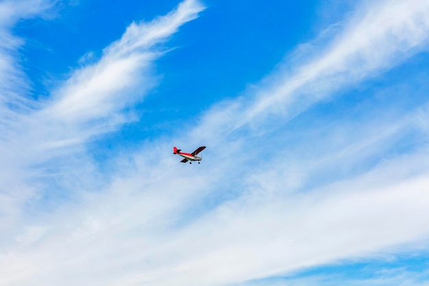 Mały czerwony samolot na niebieskim niebie