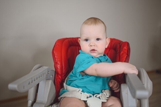 Mały emocjonalny noworodka zabawny maluch chłopiec siedzi na karmieniu wysokiego krzesełka wyraz twarzy dziecka i