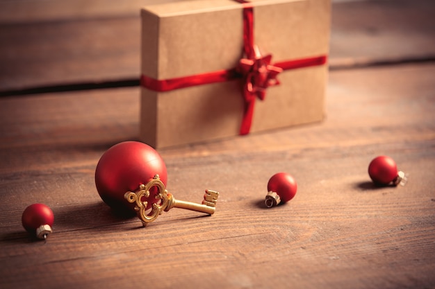 Mały klucz i pudełko świąteczne na drewnianym stole