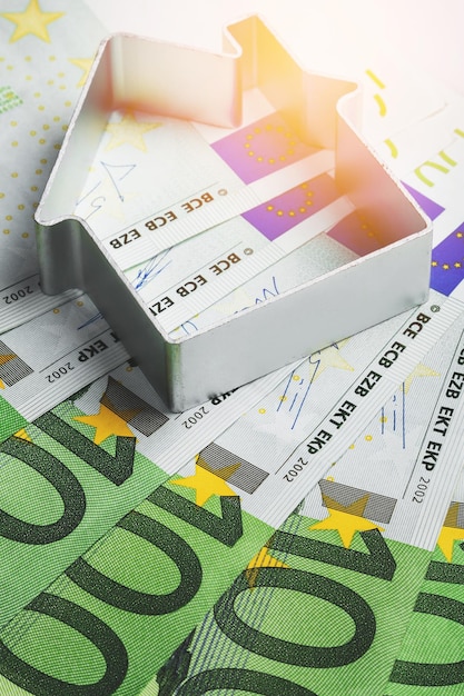 Mały metalowy domek i banknoty euro Pojęcia inwestycji płatność rachunków lub podatków