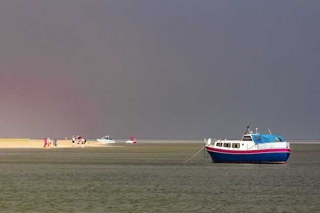 Mały niebieski statek pasażerski zacumowany w zatoce Morza Bałtyckiego
