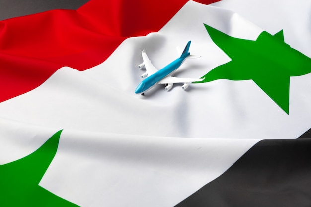 Mały samolot-zabawka nad flagą z Syrii
