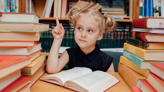 Mały śliczny dziewczyny czytanie w bibliotece