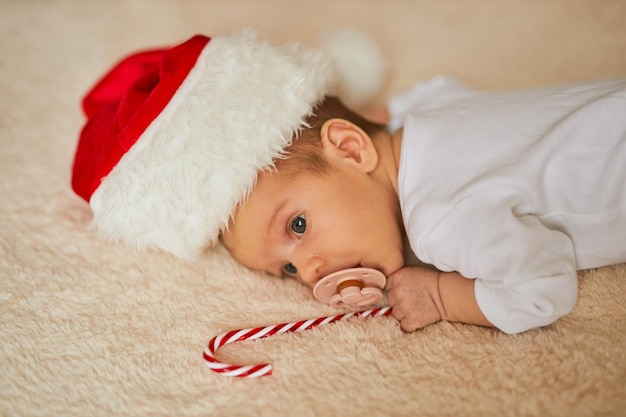 Mały śpiący noworodek w kapeluszu Mikołaja