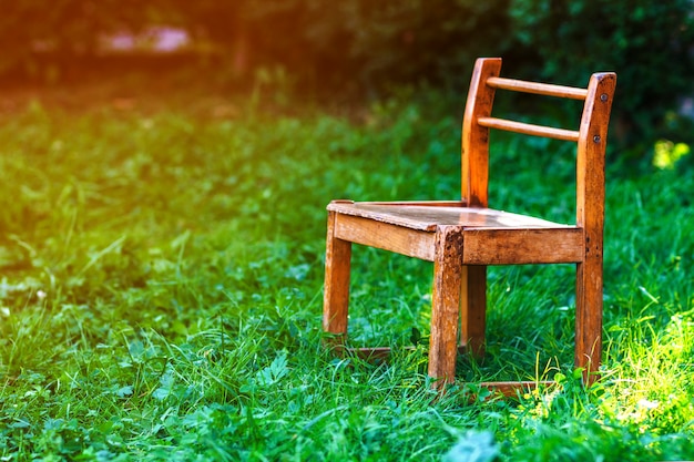 Mały stary krzesło na zielonej trawie