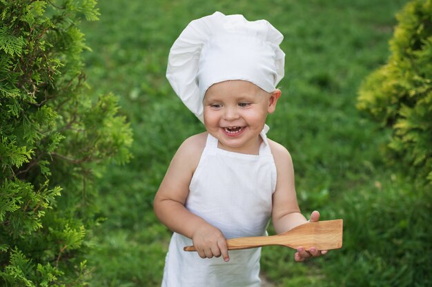 Mały szczęśliwy szef kuchni na pinkinie outdoors