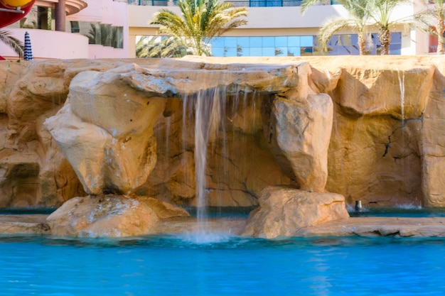 Mały wodospad z turkusową wodą w hotelowym basenie
