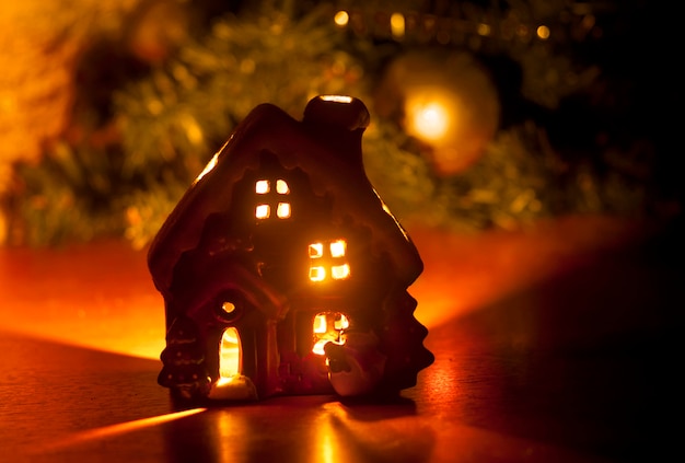 Zdjęcie mały zabawkowy domek bożonarodzeniowy z płonącym światłem w środku