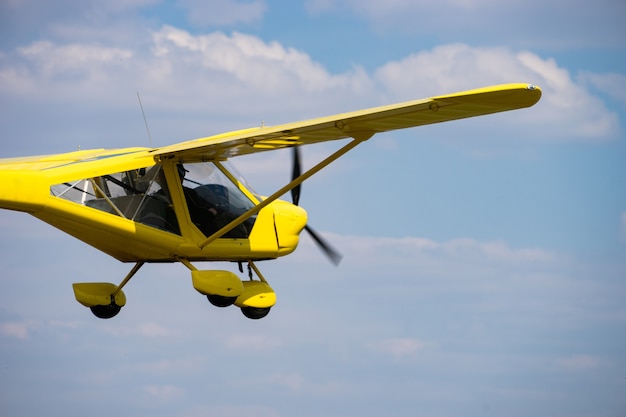 Mały żółty Prywatny Samolot Lecący W Błękitne Niebo.