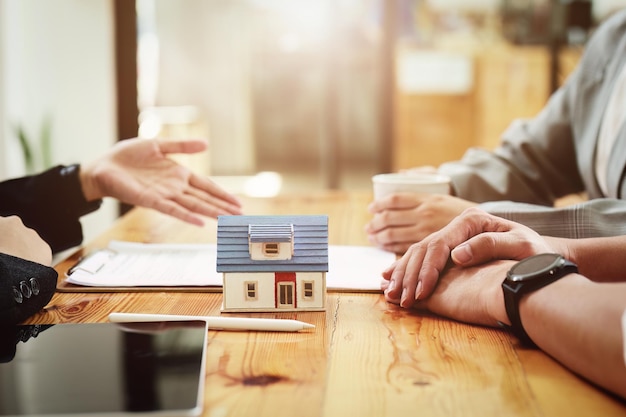 Małżonek zawierający umowę o mieszkanie czyta warunki umowy oprocentowania kredytu, którą oferuje urzędnik banku lub agent nieruchomości przed podpisaniem