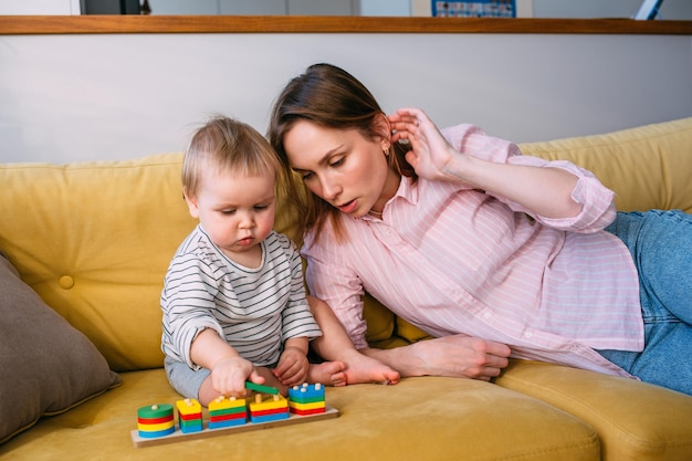 Mama bawi się w domu z małym dzieckiem na kanapie baw się dobrze