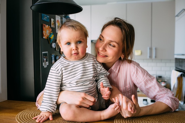 Zdjęcie mama bawi się w domu z małym dzieckiem na kanapie zabawiaj się