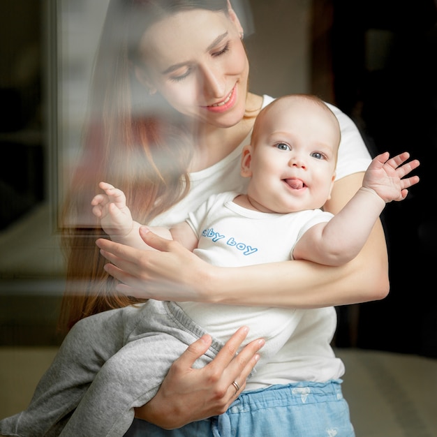 Mama bawi się z dzieckiem 6 miesięcy na łóżku w domu